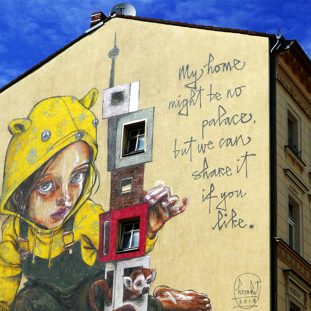 street art mural on house by artist Herakut in Berlin Kreuzberg with blue sky in the background