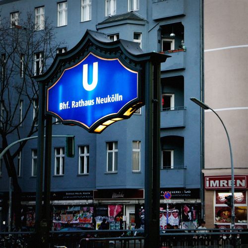 Berlin U-Bahn station sign for Bhf. Rathaus Neukölln with illuminated blue shield and gold trim